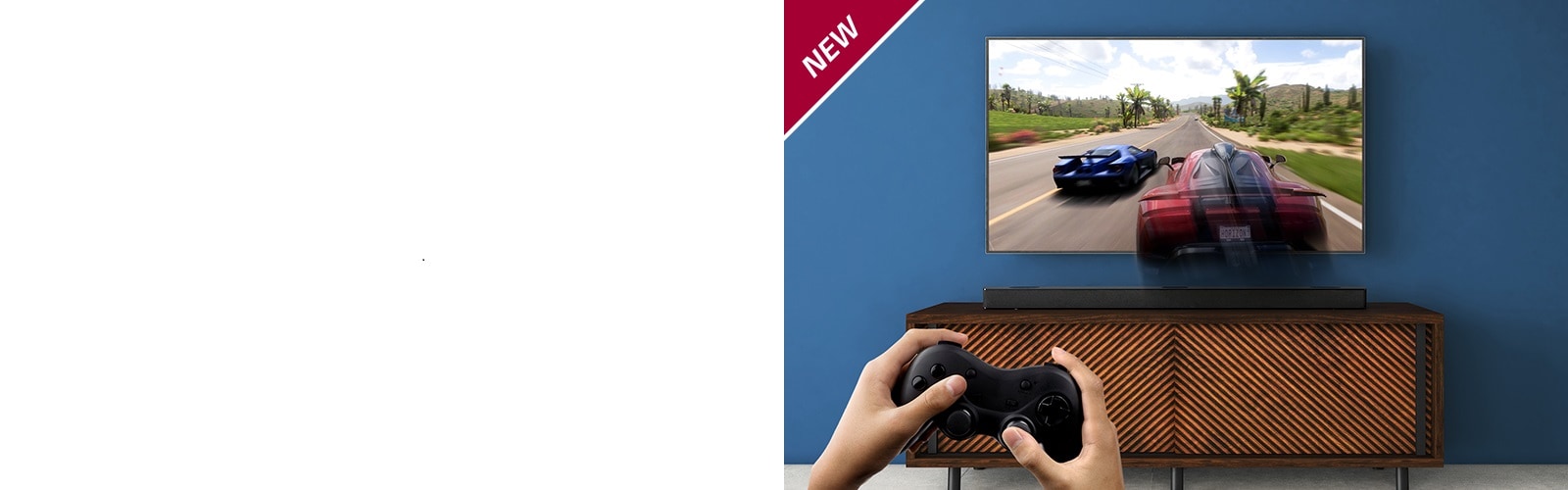 LG TV is on the wall, showing a racing game. LG Sound Bar is place on the brown shelf, right below LG TV. A man is holding a joy stick. NEW mark is shown in the top left corner.