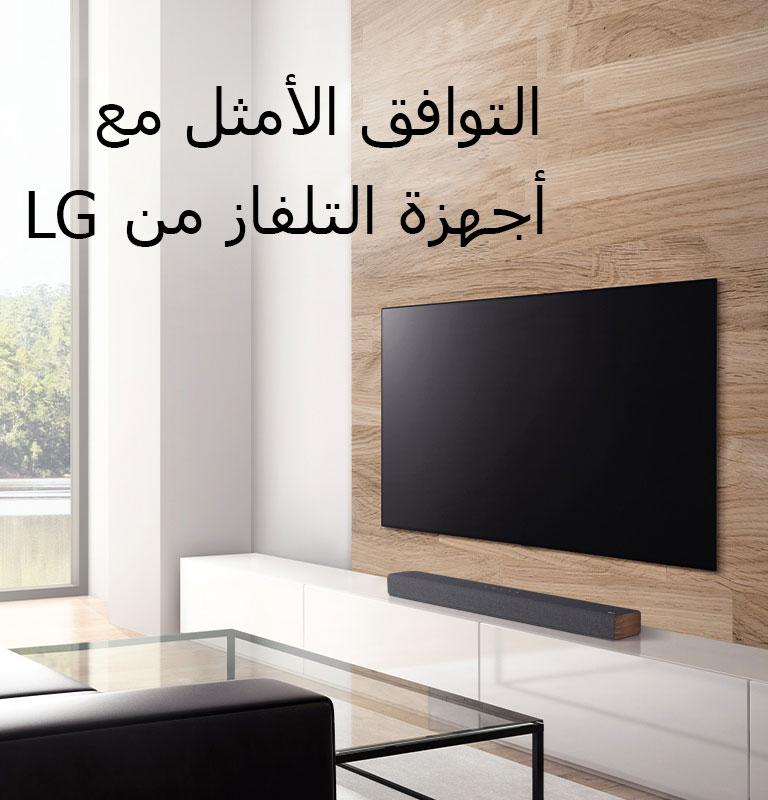 توجد سماعة في كابينة التلفاز البيضاء ويوضع التلفاز على جدار خشبي. هناك مشهد غابة خارج النافذة. نص مكتوب على الصورة - التوافق الأمثل مع أجهزة التلفاز من LG. 