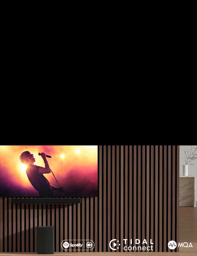 LG OLED C se coloca en la pared, debajo LG Sound Bar SC9S se coloca a través de un soporte exclusivo. El subwoofer se coloca debajo. La televisión muestra una escena de conciertos.