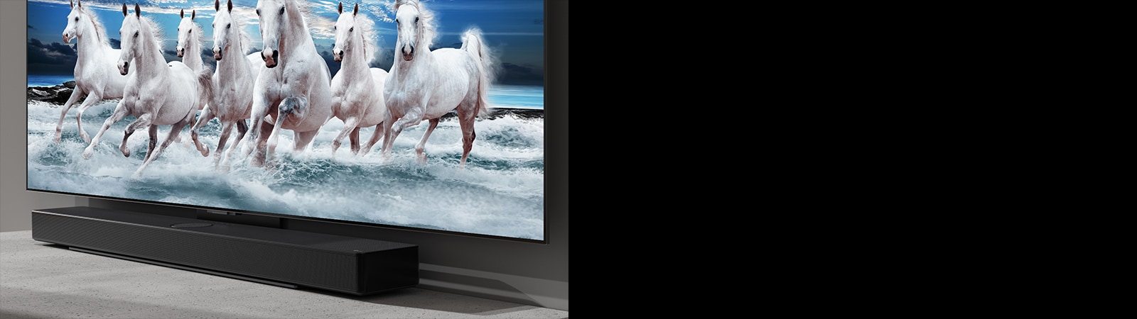 Sound bar and TV are placed on the white table and 7 white horses are shown on the TV.