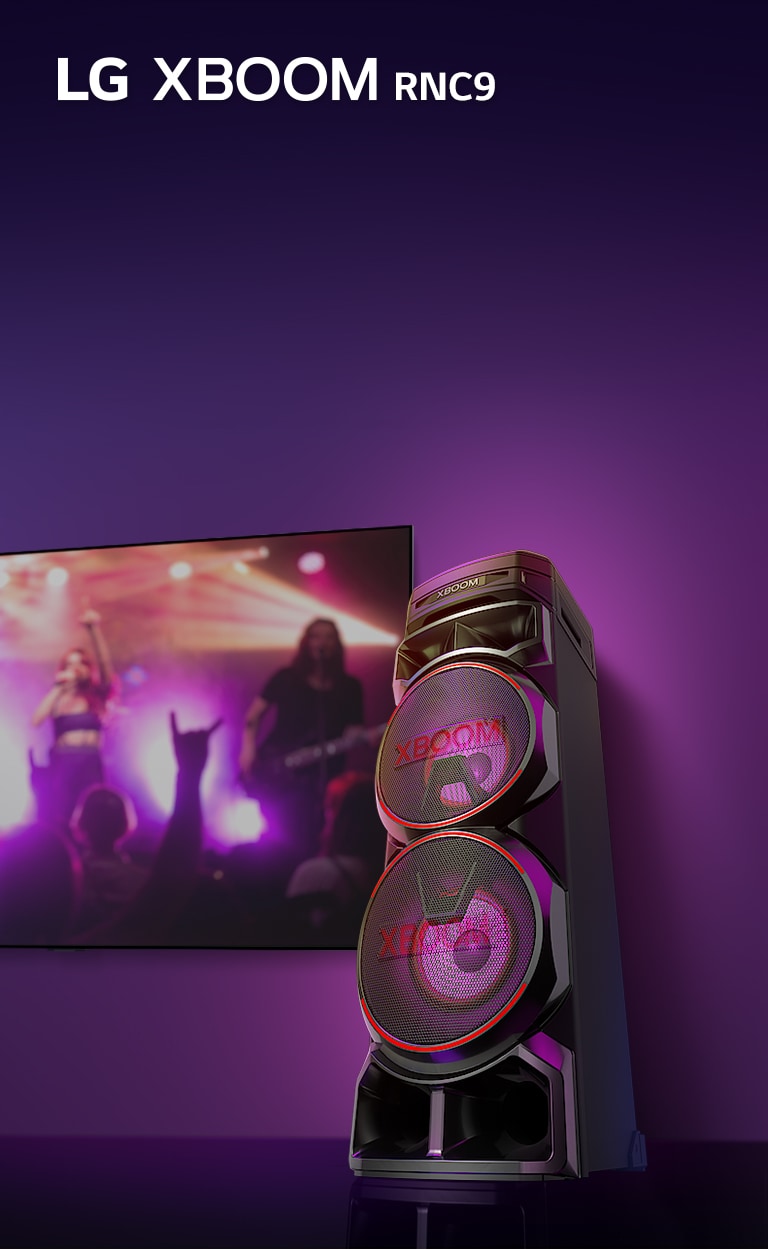 Изглед под нисък ъгъл на дясната страна на LG XBOOM RNC9 на пурпурен фон. Светлината на XBOOM също е пурпурна. И телевизионен екран, на който се показва концертна сцена.