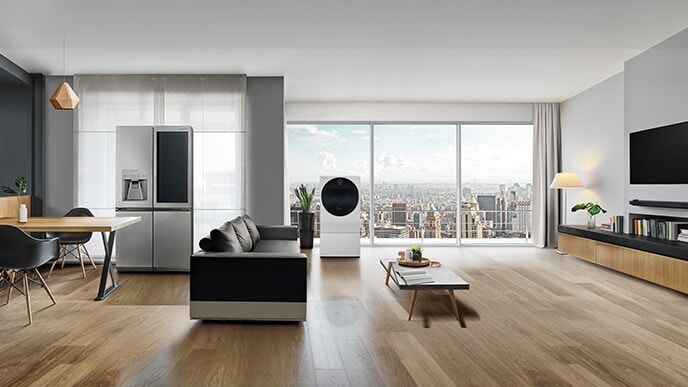 Le réfrigérateur LG SIGNATURE, le lave-linge et le téléviseur OLED W sont affichés dans le salon avec une vue sur la ville au-delà de la fenêtre.