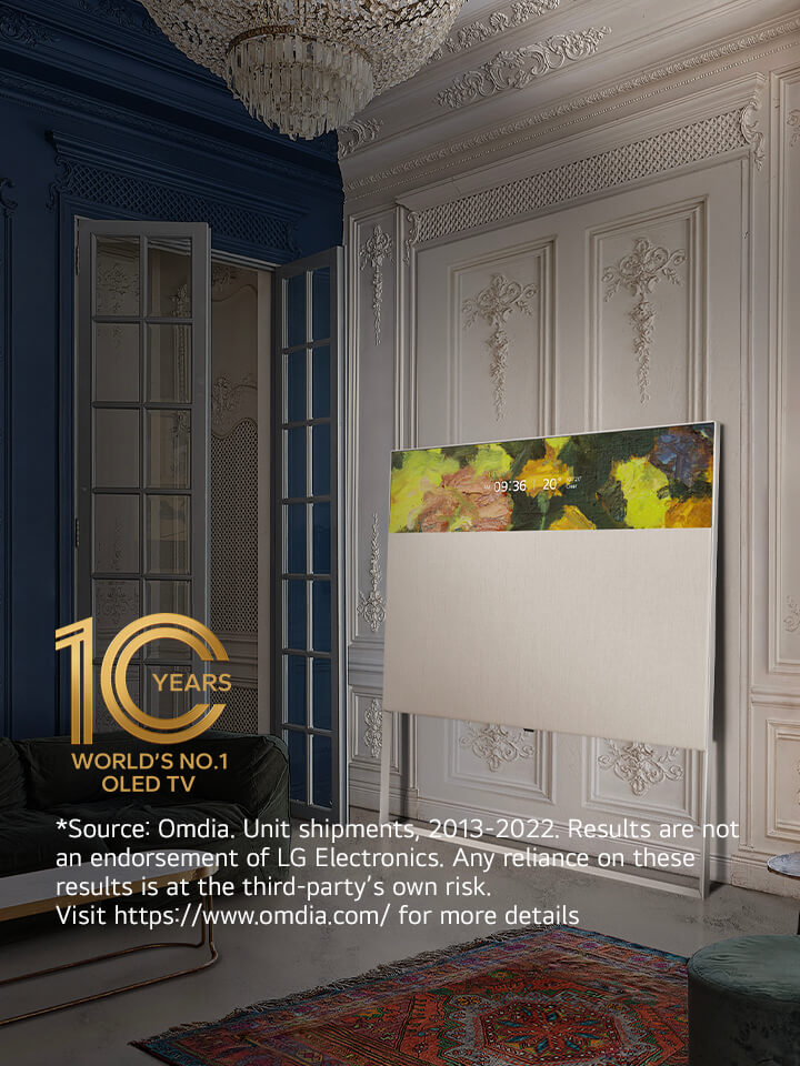 EASEL in Line View leaning against a wall with decorative molding. It sits next to a painting on the wall and behind an intricately designed rug. 10 Year World's No.1 OLED TV emblem.