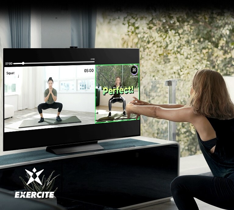 Una donna fa degli squat mentre guarda il televisore. All'interno dello schermo televisivo vediamo immagini che le insegnano gli esercizi e controllano la sua postura.