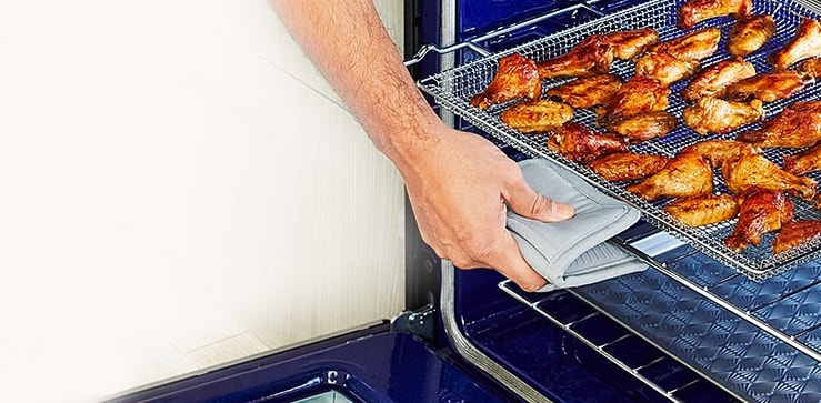 La imágen de abrir el horno y sacar una ala de pollo bien cocida.