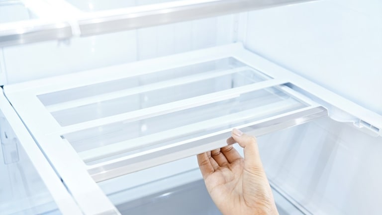 Puxar o compartimento deslizante no frigorífico com a mão