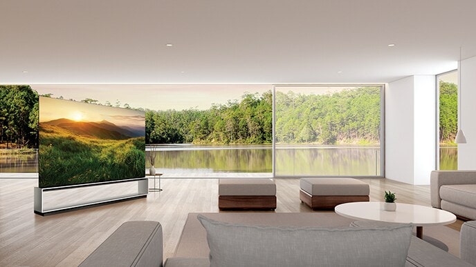 LG SIGNATURE OLED 8K TV muestra la vista de la montaña en su pantalla mientras se coloca en la sala de estar con el paisaje verde más allá de la ventana.