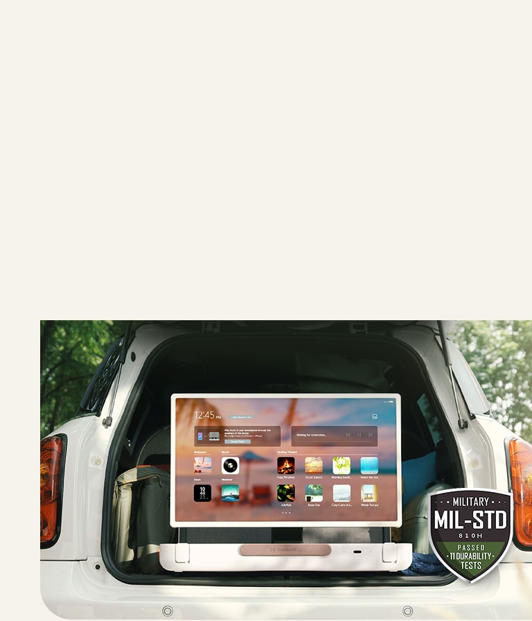 Front view of LG StanbyME Go. The product is placed in the car, the screen rorated horizontally, showing home screen. On the bottom-left side of the image, military spec icon is shown.