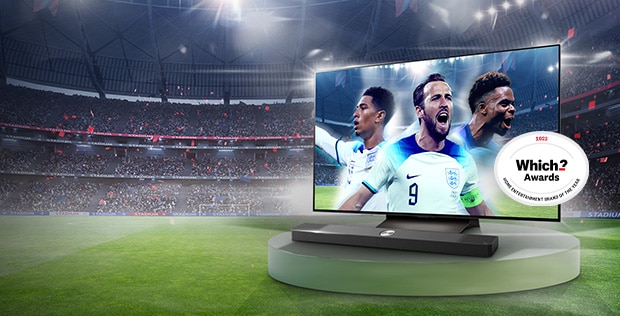 large LG OLED TV on a stand with england's football players on the screen placed on the pedestal with a stadium in the background and which? award badge on the right side of the tv 