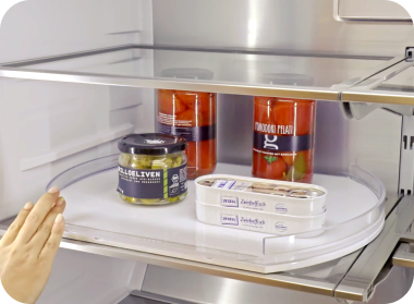 A rotating shelf with various barrels is placed on the inside of the refrigerator.