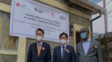 Three men wearing masks stand in front of Ethiopia's veterans' villages, wearing suits and supporting LG's remodeling.