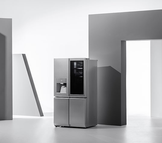 LG SIGNATURE Kühlschrank steht zwischen geometrischen Figuren.