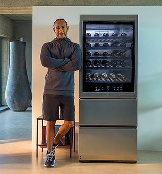 Lewis Hamilton lehnt sich an den LG SIGNATURE Weinkühlschrank an.