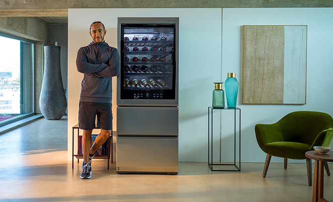 Lewis Hamilton lehnt sich an den LG SIGNATURE Weinkühlschrank an.