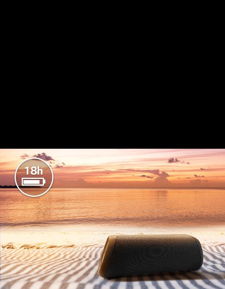 El altavoz se coloca sobre una toalla de playa. Frente al altavoz, se muestra la puesta de sol en la playa para ilustrar que este altavoz se puede reproducir hasta 18 horas.