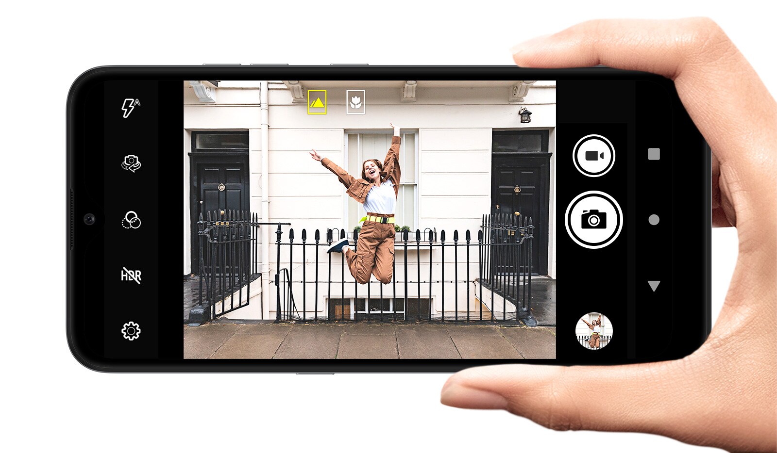 Smartphone tomando una foto de una mujer que posa y salta en la calle