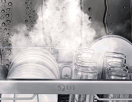 لقطة مقربة للأطباق والأكواب التي يتم غسلها بالبخار داخل غسالة الأطباق.