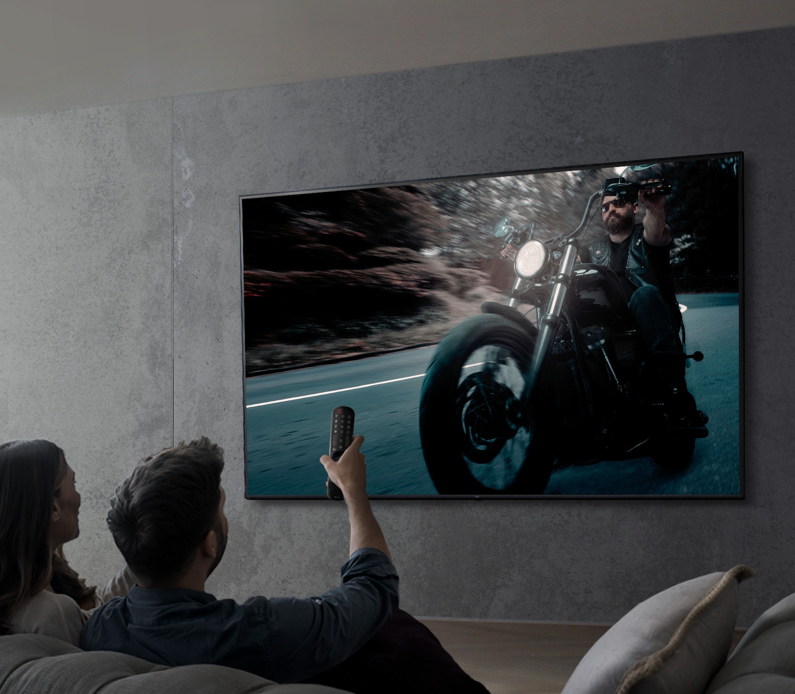 صورة يظهر فيها شخصان يشاهدان عرضًا على شاشة تلفاز UHD من LG.