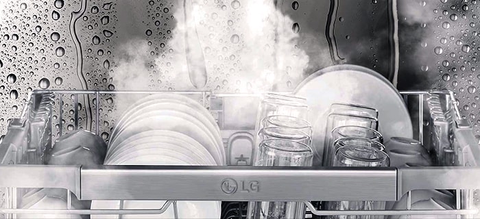 Close-up of dishes and glasses being steam-washed inside dishwasher.