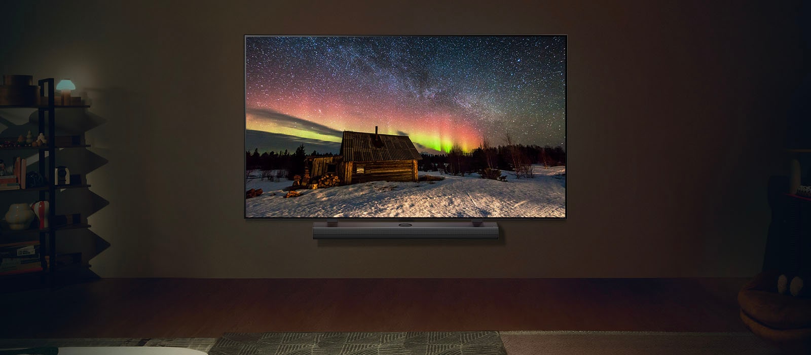 LG-televisio ja LG Soundbar modernissa olohuoneessa yöllä. Näytöllä kuva revontulista ihanteellisilla kirkkaustasoilla.
