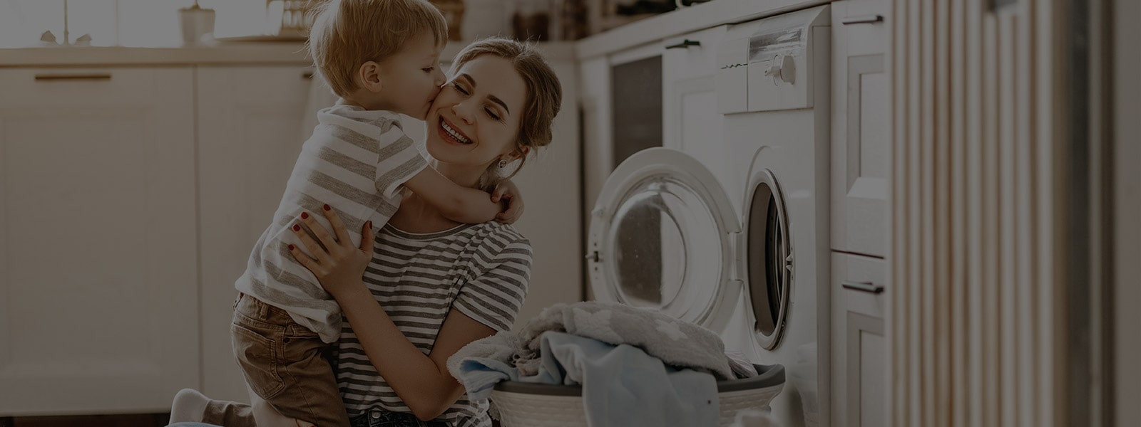 It's an image of a mother and a baby sitting in front of a washing machine.