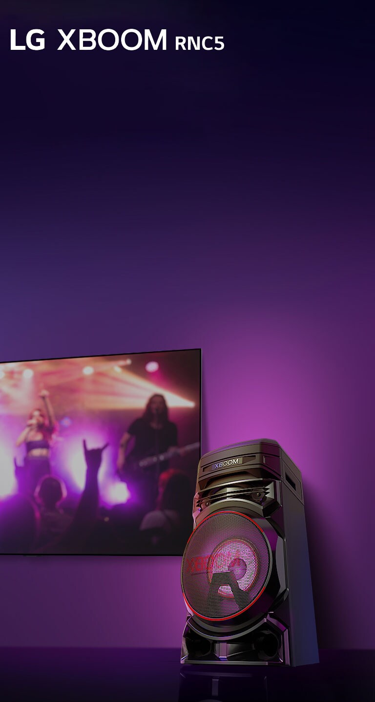 "Az LG XBOOM RNC5 jobb oldala alacsony szögből fényképezve, lila háttérrel.  Az XBOOM fénye is lila. Egy TV képernyőjén pedig egy koncertjelenet jelenik meg."