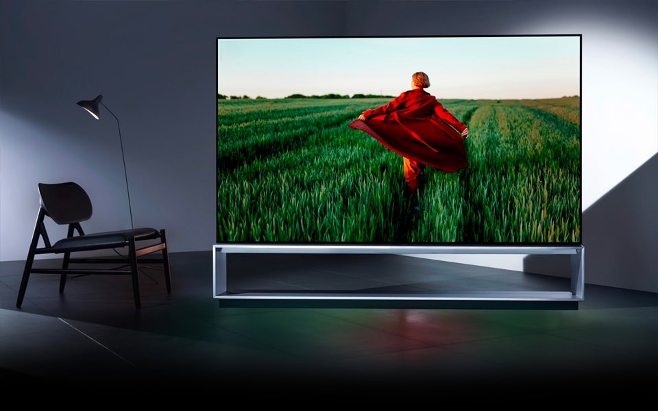 Telewizor LG SIGNATURE OLED przedstawia osobę biegnącą przez pole.