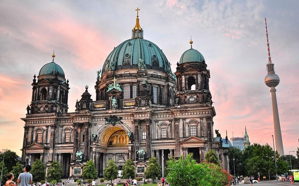 Podróżuj po Berlinie: Katedra w Berlinie o zachodzie słońca, z wieżą telewizyjną w tle.