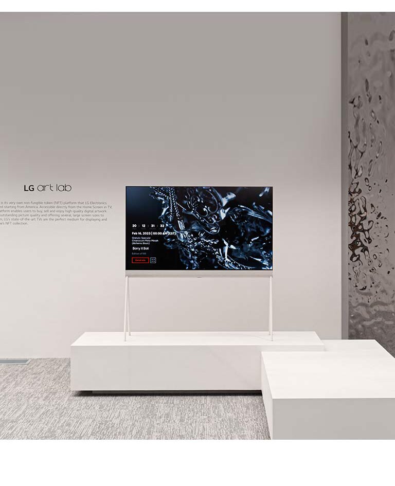 На экране телевизора Easel в белой комнате демонстрируется цифровая иллюстрация черной скульптуры. В серебряной физической скульптуре, расположенной справа от телевизора, отражается комната.