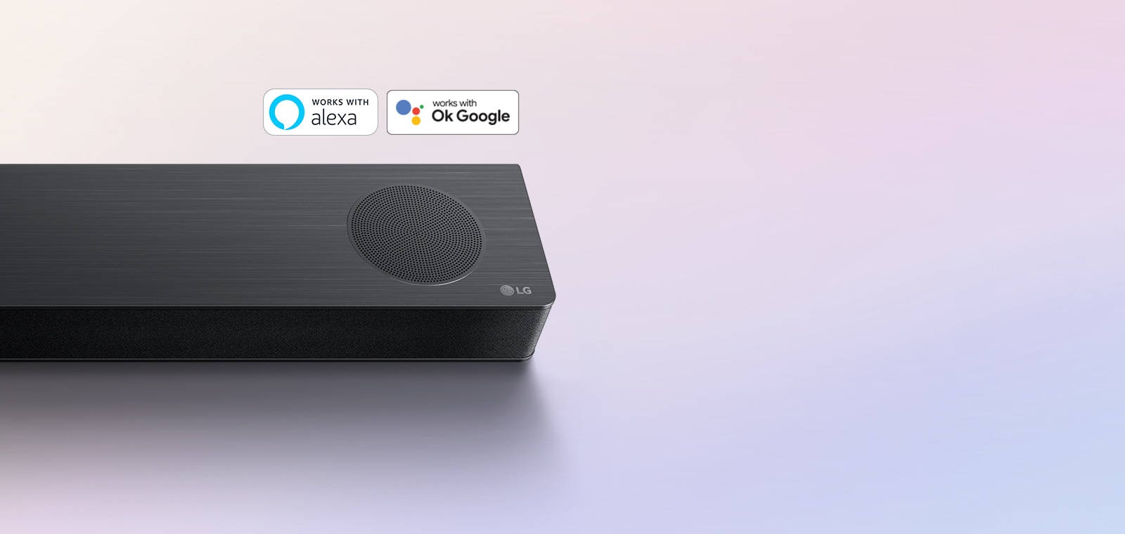 LG Soundbar står på marken och LG:s logotyp är synlig i soundbarens högra hörn. Logotyperna för Alexa och OK GOOGLE är synliga på soundbaren.
