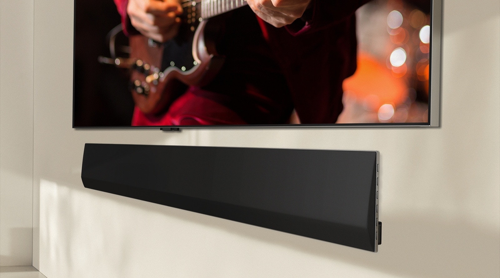 Ett vinklat perspektiv av undersidan av en LG TV och LG Soundbar, monterade mot väggen.