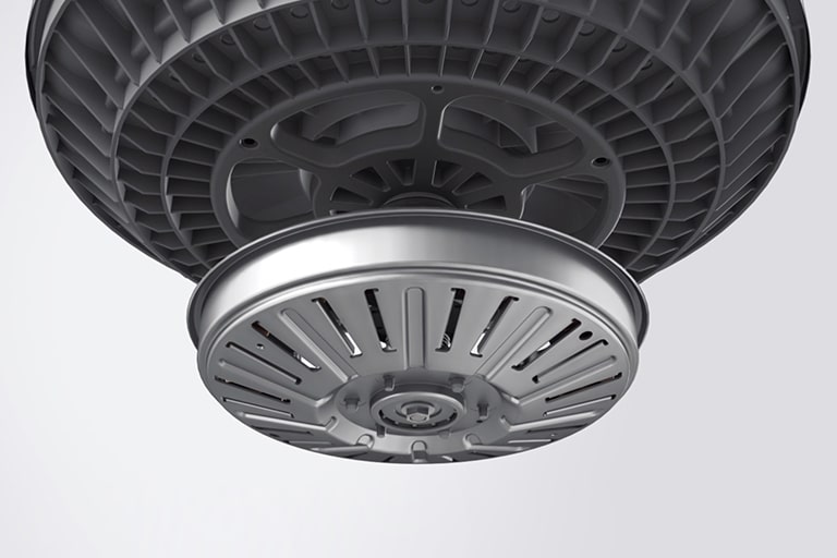 A close-up view of a lg washing machine's motor and tub. The motor is a circular disc with a metal plate underneath it.