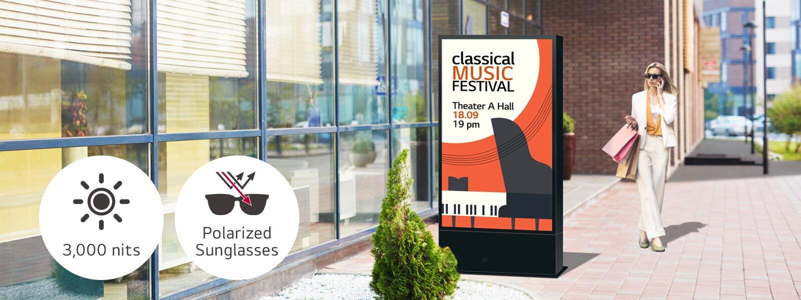 A large-sized display is installed on the street, and a woman is looking at a vivid-quality advertisement on the screen.