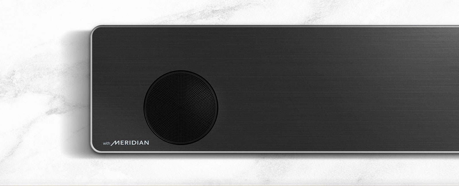 Close-up of the left side of LG Soundbar with Meridian logo on the bottom left corner.