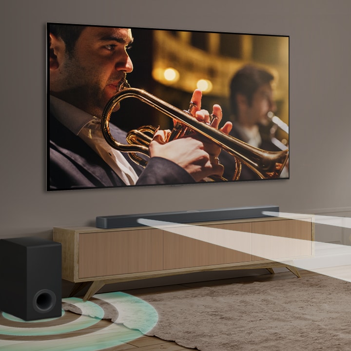 An LG Soundbar, LG TV, and subwoofer are in a modern city apartment. The LG Soundbar emits three branches of soundwaves, made of white droplets that float along the bottom of the floor. Next to the Soundbar is a subwoofer, creating a sound effect from the bottom.
