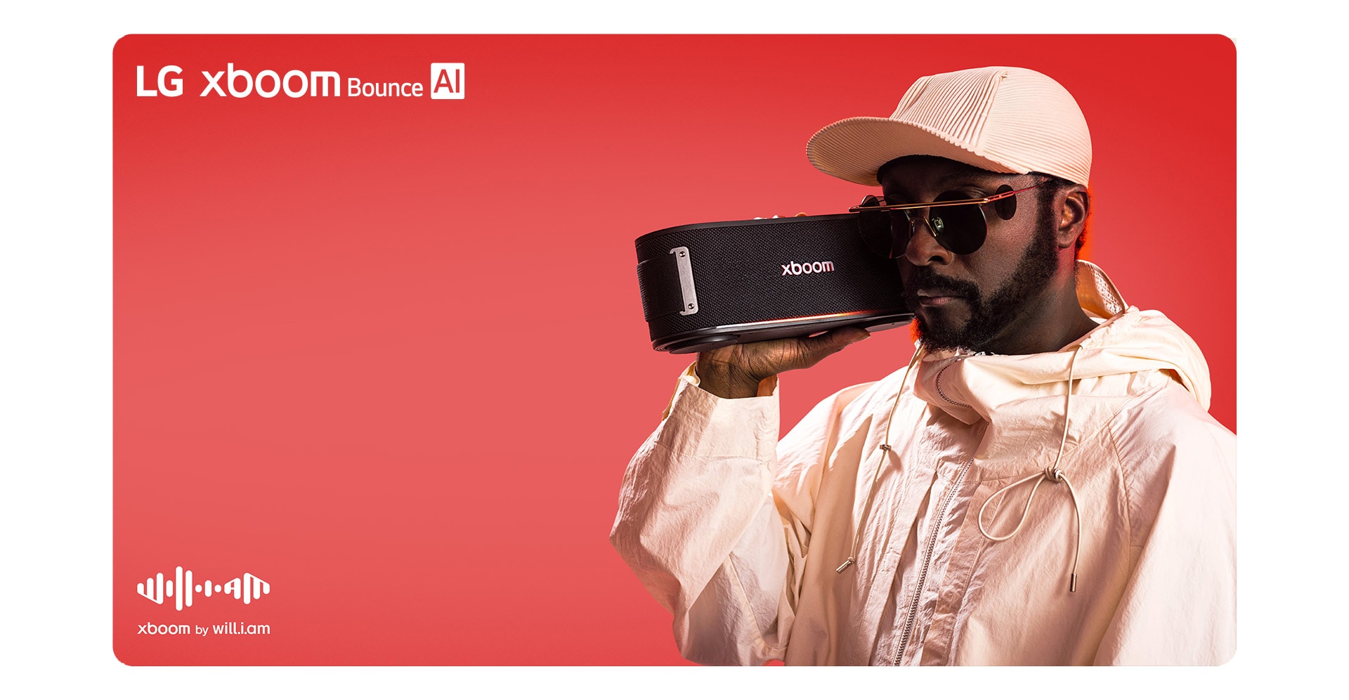 will.i.am in white outfit and sunglasses is holding xboom Bounce right next to his face.