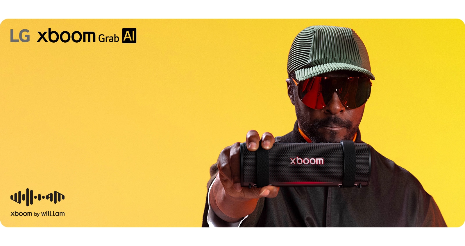 will.i.am in black outfit and sunglasses is holding xboom Grab to the front.	