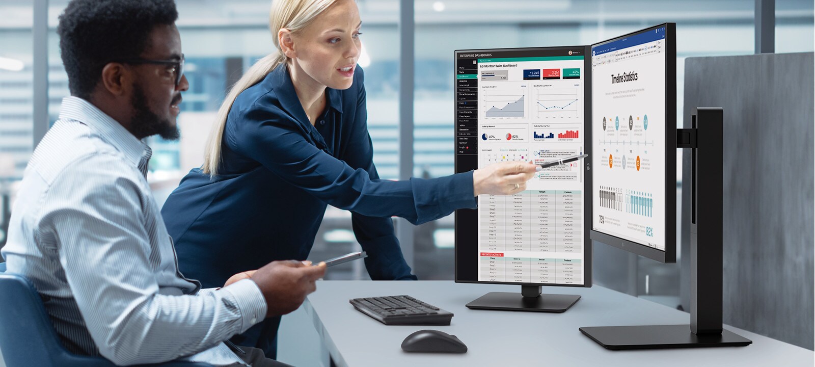 Two male and female employees discuss while looking at the monitor in the office.	