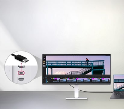 A USB Type-C cable connected between a laptop and an ultra-wide LG monitor displaying a video editing interface, with a close-up showing the USB-C port on the monitor.	