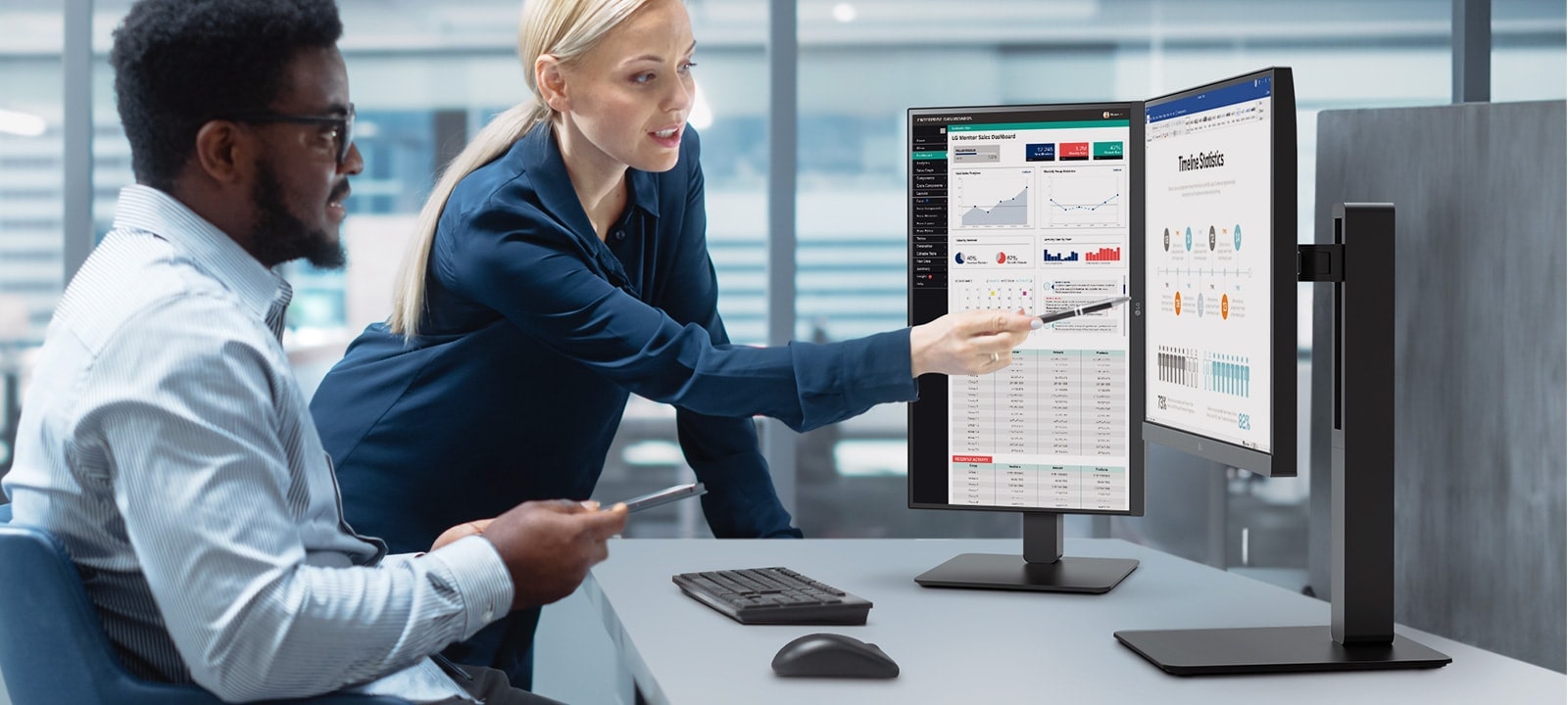 Two male and female employees discuss while looking at the monitor in the office.	