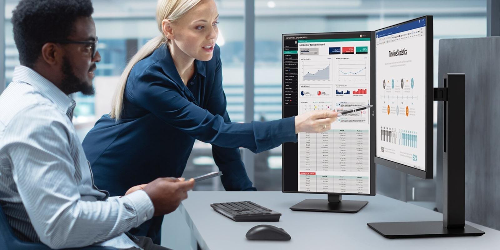 Two male and female employees discuss while looking at the monitor in the office.	