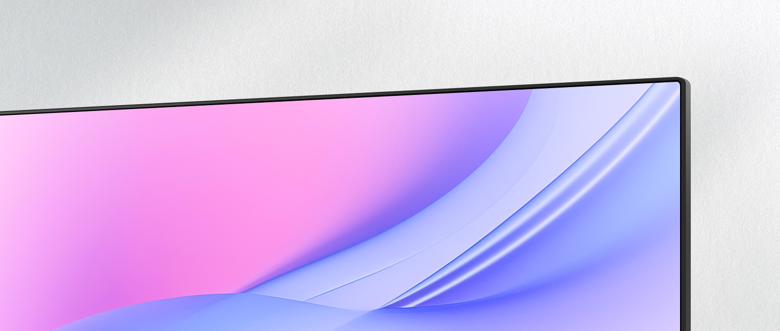 A close-up angled view of a monitor's upper-right corner, showcasing its ultra-slim bezel and seamless screen design. The display features a smooth pink-to-blue gradient, emphasizing a clean and modern aesthetic ideal for minimalistic setups.