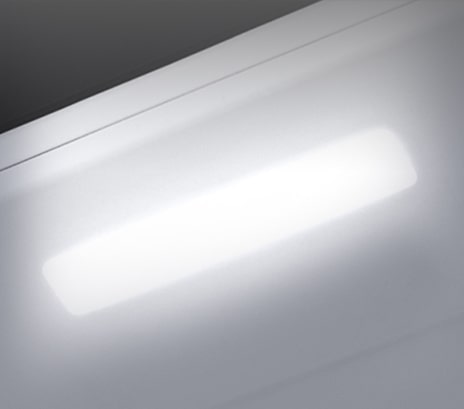 The top interior of the fridge is shown with the soft LED light bright.	