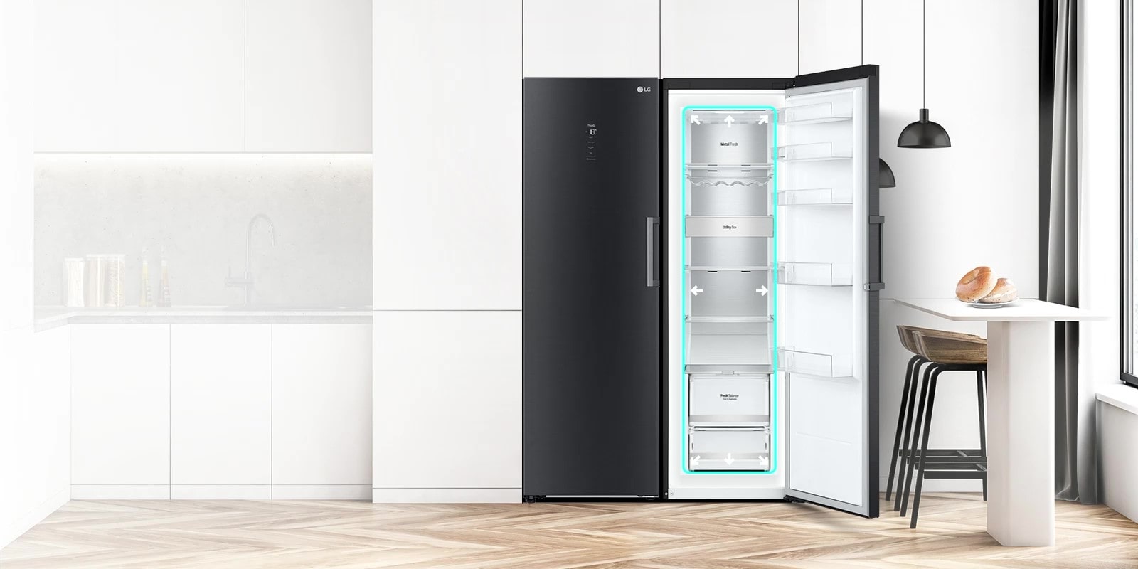 The front view of the fridge is shown in a kitchen with the door open and displaying the produce inside. A blue square highlights the interior with arrows pushing out to indicate there is ample room inside.	