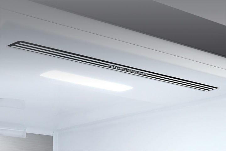 The top interior of the fridge is shown with the soft LED light bright.	
