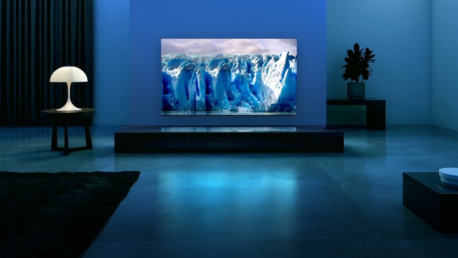 A blue neon circuit moves around on blue glacier image. The camera zooms out and shows this blue glacier within TV screen. The TV is placed in a wide living room with blue background. 