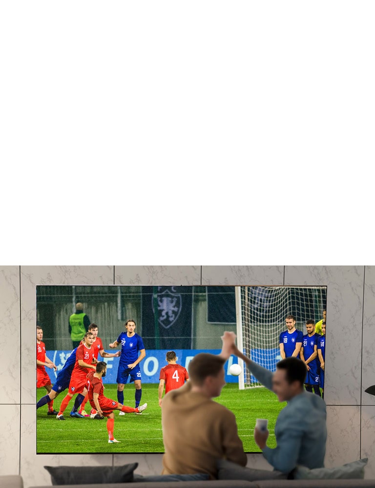 People watching sports game on TV in the living room with ultra large scree TV