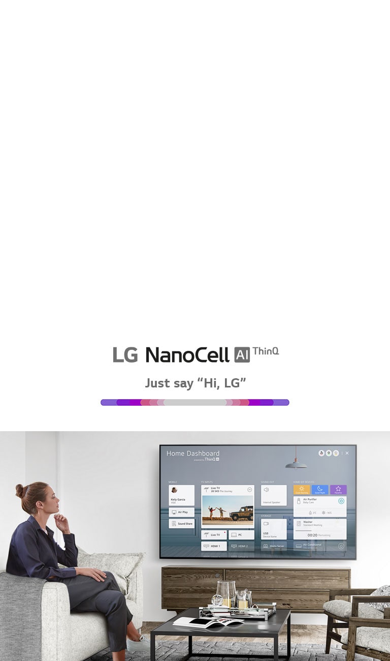 A women sitting on a sofa in the living room with the Home Dashboard on the TV screen