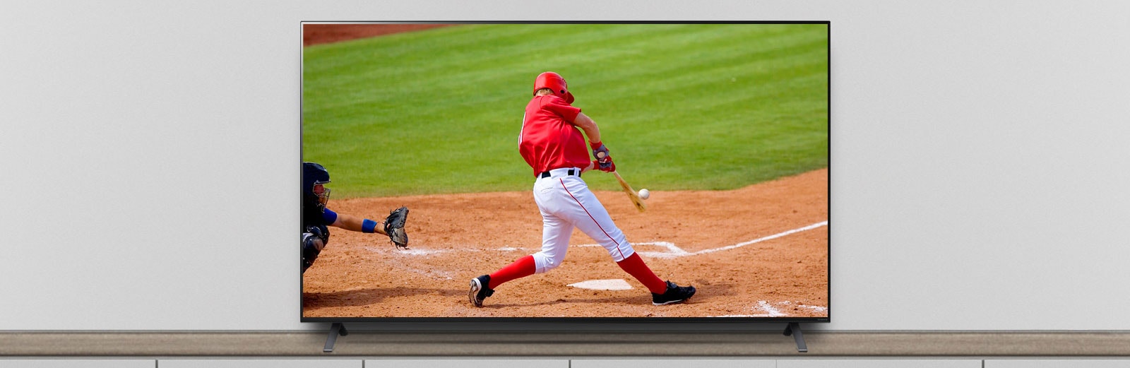 The TV is on the stand, and the screen shows a baseball match.