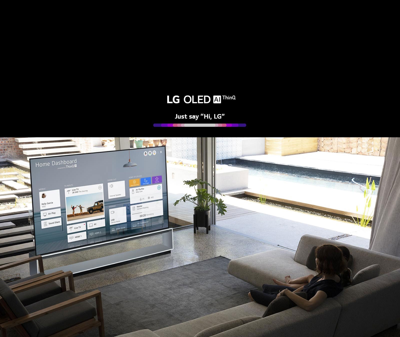 Mother and daughter sitting on a sofa in the living room with the Home Dashboard on the TV screen